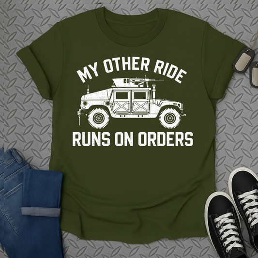 Green t-shirt with a white graphic of a military vehicle and text "MY OTHER RIDE RUNS ON ORDERS".